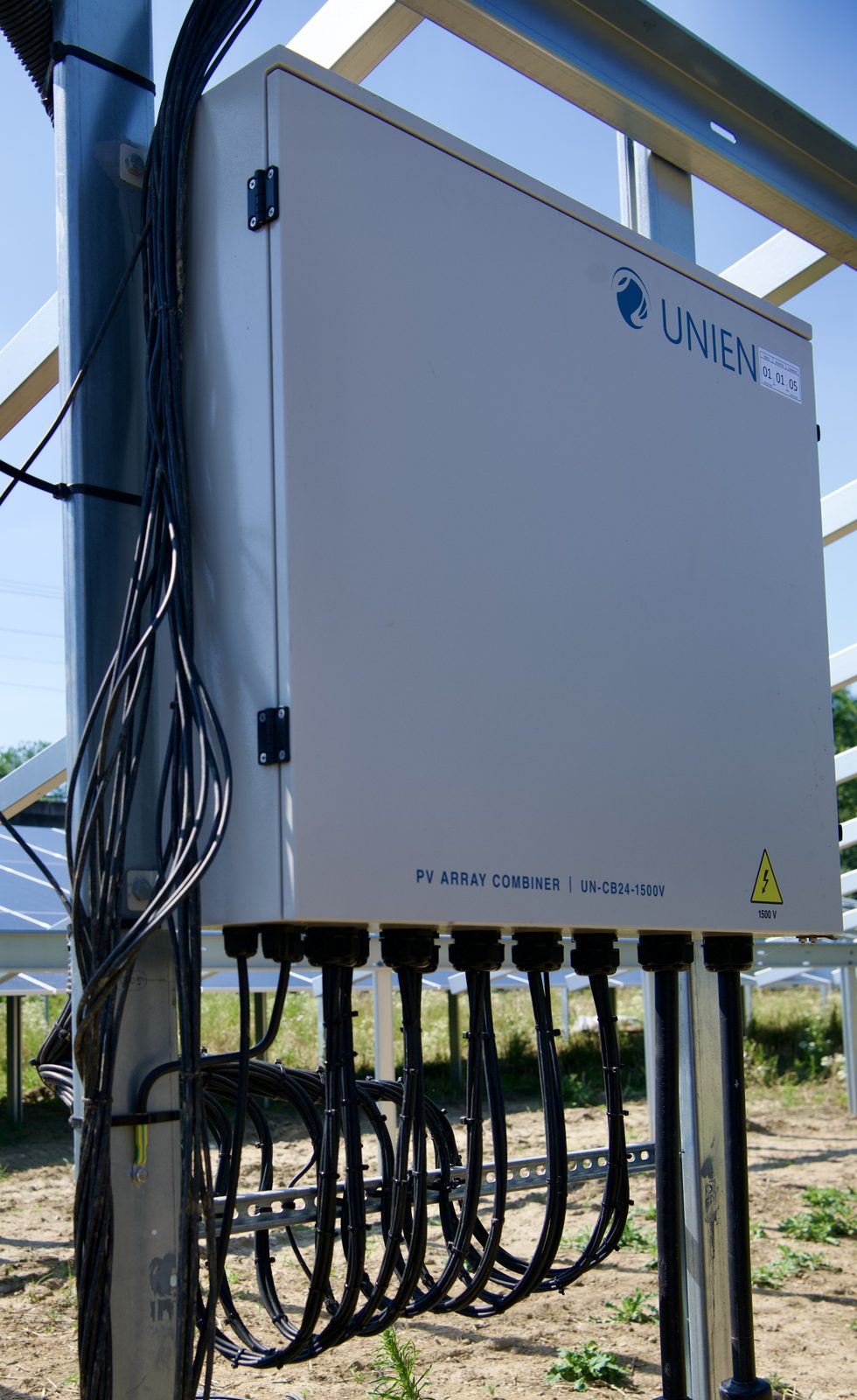 UNIEN Combiner Box UN-CB24-1500V am Modultisch montiert, mit Box-ID-Kennzeichnung und sauber geführten DC-Kabelschlaufen