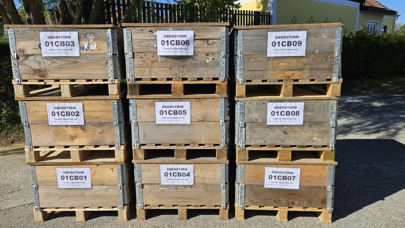 Beschriftete Mehrwegholzpaletten mit Kabelsträngen, gestapelt in 3x3 Anordnung