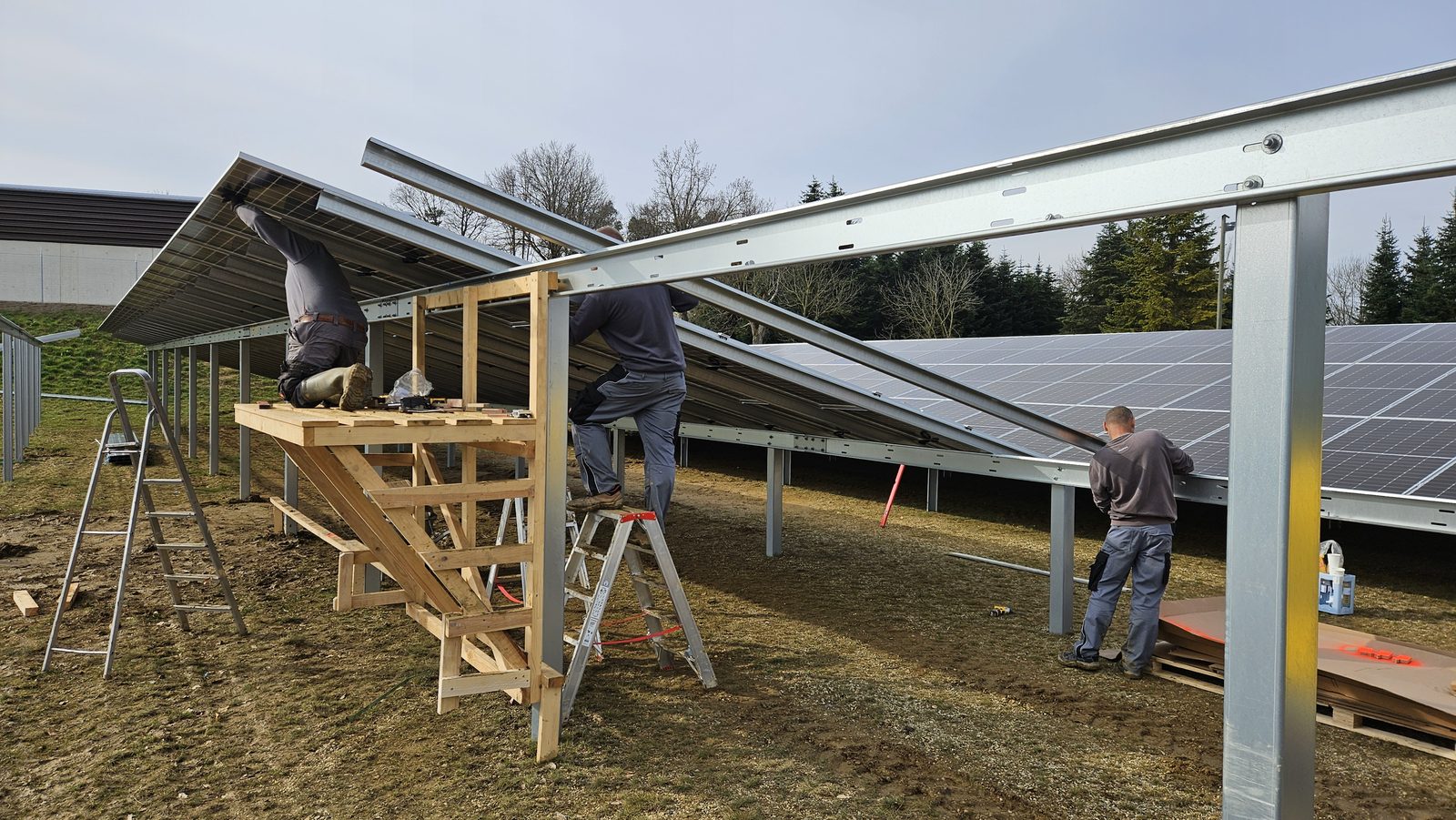 Monteure setzen PV-Module auf die geneigte Unterkonstruktion