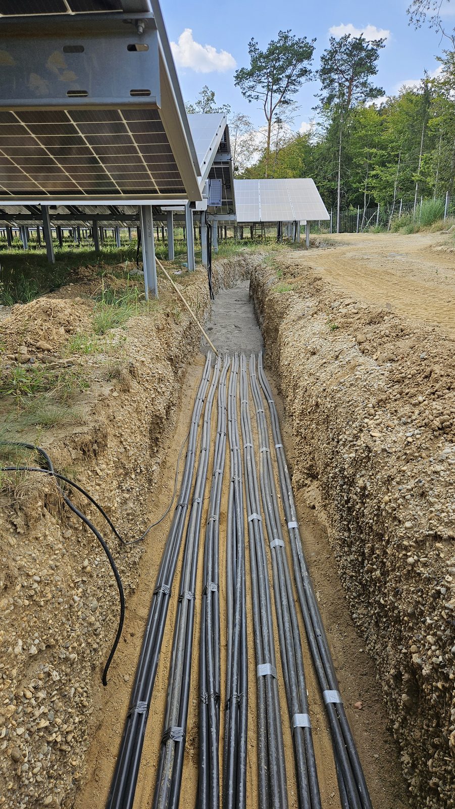 Sauber gefächerte und gebündelte DC-Kabeltrasse in Schutzrohren am Sammelgraben im PV-Park Sebersdorf